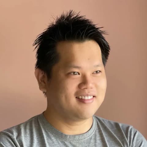 Aaron Cheah smiling in a grey T-shirt